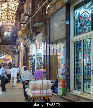 Teheran, Iran - 22. MAI 2017: Besetzt Grand Bazaar Street mit Reihen von Zählern und Schuhe shop Windows, Mann, mit Warenkorb Stockfoto