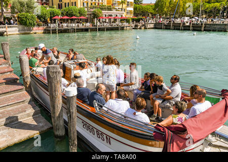 SIRMIONE, Gardasee, Italien - September 2018: Menschen auf ein kleines Motorboot über den Weg auf einer Sightseeingtour rund um Sirmione am See Gar fest sitzen Stockfoto