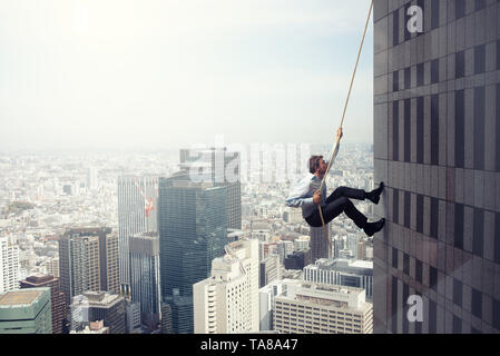 Geschäftsmann klettert ein Gebäude mit einem Seil. Konzept der Bestimmung Stockfoto