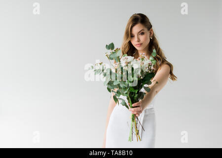 Selektiver Fokus der attraktive Mädchen, dass Strauß Blumen auf Weiß Stockfoto