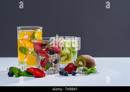 Verschiedenen bunten Smoothies oder Säfte in Flaschen und Zutaten auf Dunkel. Gesunde Ernährung detox vegan Clean Food Konzept, Ansicht von oben. Stockfoto