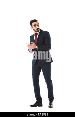 Überrascht, Geschäftsmann, schauen, während Sie ihr Smartphone isoliert auf weißem Stockfoto