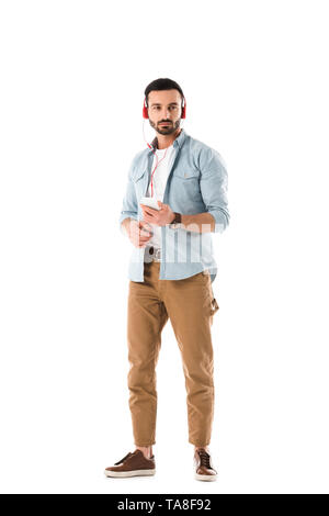 Nachdenkliche Menschen Musik hören über Kopfhörer und Holding smartphone isoliert auf weißem Stockfoto