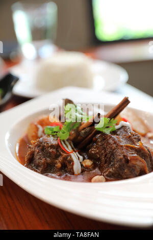 Rindfleisch Massaman Curry mit Reis und Salat auf Holz- Hintergrund, Thai Food Stockfoto