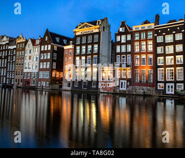 Damrak Grachtenhäuser bei Nacht - Amsterdam Canal House Reflexion tanzen Häuser von Damrak Reflexionen in der Nacht - reflektierende Häuser canal Damrak. Stockfoto