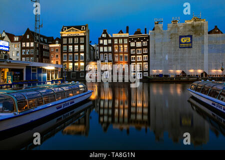 Damrak Grachtenhäuser bei Nacht - Amsterdam Canal House Reflexion tanzen Häuser von Damrak Reflexionen in der Nacht - reflektierende Häuser canal Damrak. Stockfoto