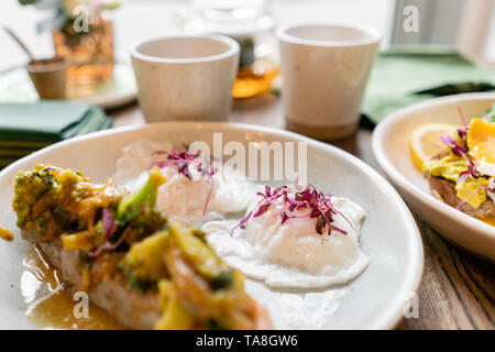 Gegrillter Lachs oder Forelle mit Brokkoli champignons Soße und Gemüse. Drinnen Nahaufnahme. Tisch im Restaurant in der Nähe der Fenster Stockfoto