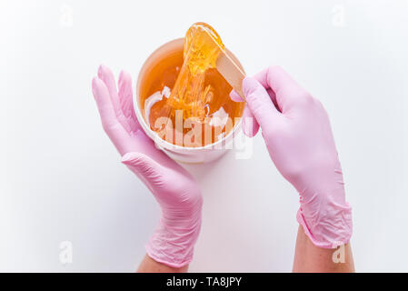 Trockenzuckerung Konzept. Flach. Ansicht der Schüssel mit kosmetologie Honig. Holzstab Stockfoto