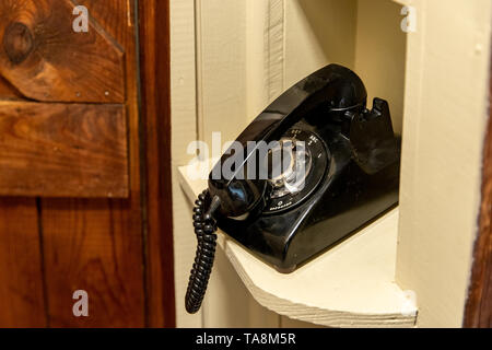 Alte schwarze Rotary Telefon, in der auf die Stellung halten, sitzen, auf dem Flur Telefon Nook Stockfoto