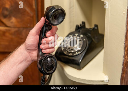 Hand Hörer des alten schwarzen Rotary Telefon im Flur Telefon Nook Stockfoto