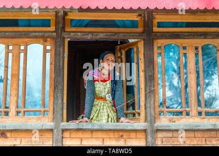 Kullu, Himachal Pradesh, Indien - Januar 25, 2019: himachali Frau in traditioneller Kleidung in ihrem Holzhaus in Winter - Stockfoto