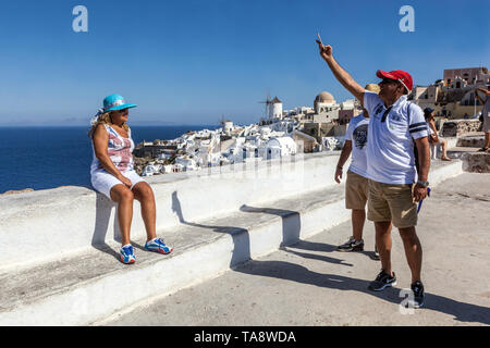 Santorini Oia, Senioren auf der Terrasse, Leute auf berühmten Aussichtspunkt, die Fotos am Telefon machen, Griechenland reist Europa Senioren reisen Urlaub Stockfoto