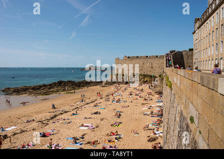 Touristische gehen auf Wälle von Intra Muros Saint Malo und Leute auf der Sandstrand, Bretagne, Frankreich Stockfoto