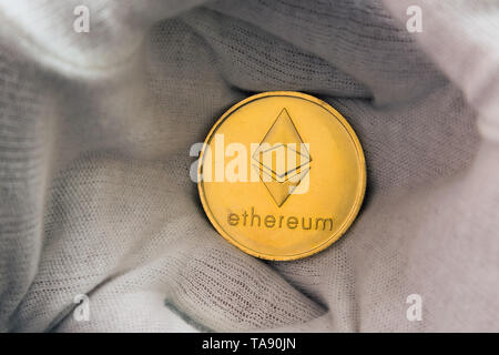 Mann im weißen Nelken Holding des Astraleums Münze zwischen Palmen. Digitale Währung, block Kette Markt Stockfoto