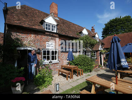 Ein Wähler hinterlässt ein Wahllokal innerhalb der Fuchs und Jagdhunde Public House in Weihnachten Gemeinsame, Oxfordshire, wie Leute auf die Umfragen für die Wahlen zum Europäischen Parlament. Stockfoto