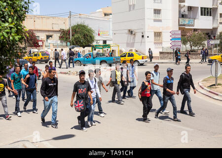 Tunesien - ca. Mai, 2012: Gruppe von Teenagern Studenten über die Straße zu Fuß auf den Straßen von tunesischen Provinzstadt. Schüler und Studenten ar Stockfoto