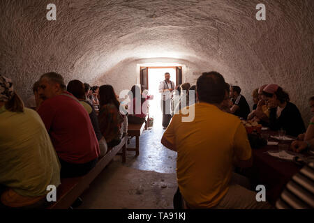 MATMATA, TUNESIEN - ca. Mai, 2012: Touristen haben Mittagessen im Bus Tour in der Wüste Sahara. Traditionelle unterirdische Höhlenwohnungen Speisesaal ist in geschnitzten Stockfoto