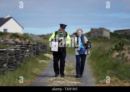 Vorsitzende Carmel McBride und Gardasee Adrian McGettigan einer Wahlurne zum Wahllokal tragen auf der Insel Inishbofin. Die Wähler auf dem entfernten Insel vor der Küste von Donegal waren unter den ersten, die ihren Stimmzettel in den lokalen und europäischen Wahlen, einen Tag vor dem Rest des Landes zu werfen. Stockfoto