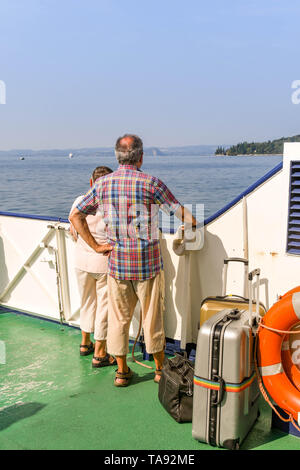 GARDA, Gardasee, Italien - September 2018: Zwei Personen mit Gepäck auf dem Deck der Fähre auf eine Reise über den Gardasee. Stockfoto