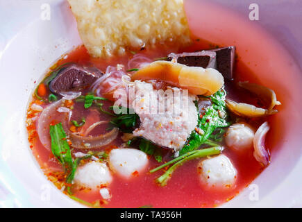 Nudeln mit Meeresfrüchten auf rote Suppe/heiß und würzig Thai Essen Nudeln mit Meeresfrüchten squid Schweinefleisch fisch Kugel und Morning glory knusprige Wan-tan Haut Schweinefleisch Blut Cubes Stockfoto