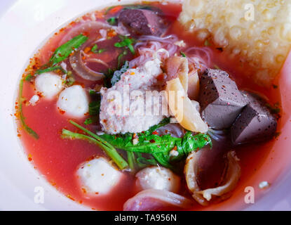 Nudeln mit Meeresfrüchten auf rote Suppe/heiß und würzig Thai Essen Nudeln mit Meeresfrüchten squid Schweinefleisch fisch Kugel und Morning glory knusprige Wan-tan Haut Schweinefleisch Blut Cubes Stockfoto