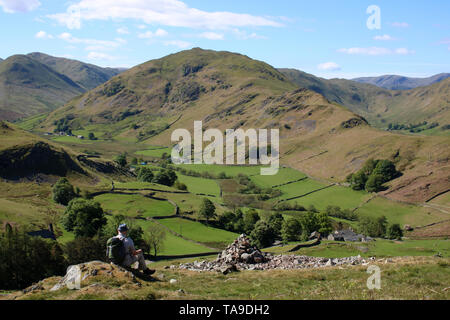 Blick nach Süden aus dem südlichen Hängen des Hallin fiel im Lake District, Cumbria mit männlichen Walker mit Blick über Martindale auf der Nab und Beda fiel. Stockfoto