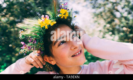 Porträt einer wunderschönen kleinen Mädchen mit Blumen Kranz. Wenig kaukasische Mädchen mit Krone aus Blumen. Stockfoto