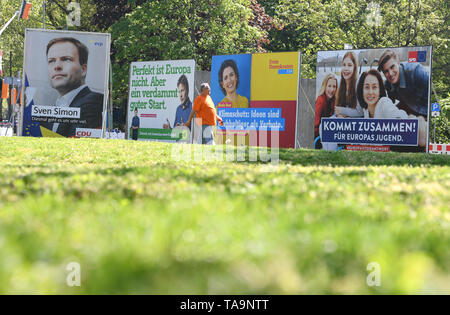 30 April 2019, Hessen, Frankfurt/Main: Michael Belzer und seinem Hund pass Wahlplakate der Parteien CDU (L-R), Bündnis 90/Die Grünen, FDP und SPD für die Wahlen zum Europäischen Parlament im Osten von Frankfurt am Main. Die direkte Wahl zum Europäischen Parlament in Deutschland am 26. Mai 2019. 4,7 Millionen Hessen sind aufgerufen zu stimmen. Foto: Arne Dedert/dpa Stockfoto