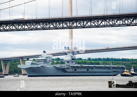 North Queensferry, Schottland, Großbritannien. 23 Mai, 2019. Flugzeugträger HMS Queen Elizabeth Segel von Rosyth in den Fluss Forth nach einem Besuch in ihrem Heimathafen für eine einbauen. Kehrt sie zu Meer für Westlant 19 Bereitstellung und ausgelegt auf den Betrieb ihrer F-35 Kampfflugzeuge zu konzentrieren. Abgebildet; Träger Pässe unter Queensferry Crossing und Forth Road Bridge Brücke bei Ebbe. Credit: Iain Masterton/Alamy leben Nachrichten Stockfoto