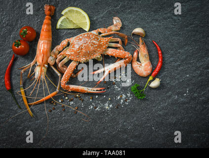 Schalentiere Seafood Platte mit Garnelen Krabben Ozean gourmet Abendessen Meeresfrüchte mit Kräutern und Gewürzen auf dunklem Hintergrund zubereitet Stockfoto