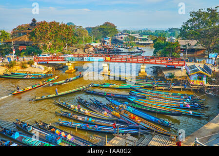 NYAUNGSHWE, MYANMAR - 19. FEBRUAR 2018: Die malerische touristische Dorf mit vielen Kajaks, entlang der Ufer des Kanals festgemacht, mit Inle L angeschlossen Stockfoto