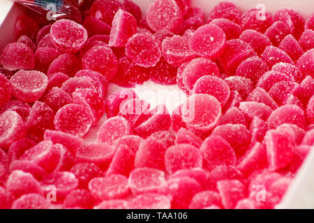 Viele Gelatine süßen roten Erdbeeren Obst Süßigkeiten Bonbons Zucker. Sortierte Farben jelly Süßigkeiten. Stapel von farbigen Süßwaren für Kinder. Gummibärchen Süßigkeiten. Stockfoto