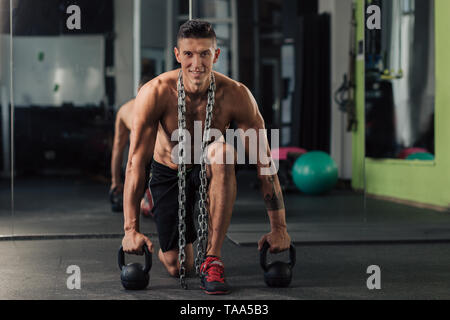 Junge muskulöse Mann in der Turnhalle tun Übung Stockfoto