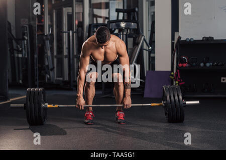 Junge muskulöse Mann in der Turnhalle tun Übung Stockfoto