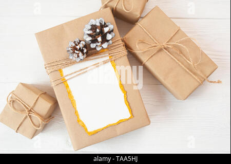 Weihnachten Hintergrund für Grußkarte Blatt Papier mit Platz für Text. Geschenkbox auf Holzhintergrund. Flach liegend, Draufsicht Fotomockup Stockfoto