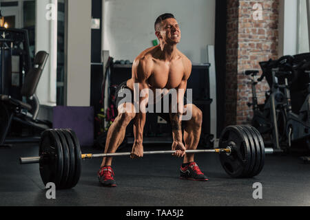 Junge muskulöse Mann in der Turnhalle tun Übung Stockfoto