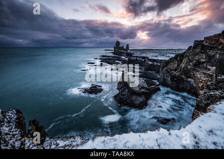 Londrangar vulkanische Felsformationen im Meer bei Schnee im Winter in Halbinsel Snaefellsnes, Island Stockfoto