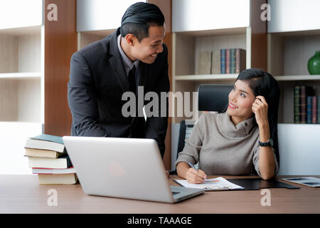 Zwei Kollegen asiatische Geschäftsmann und mit Laptop während der Arbeit am neuen Projekt Geschäftsfrau, zwei junge professionelle Arbeitgeber auf por arbeiten Stockfoto