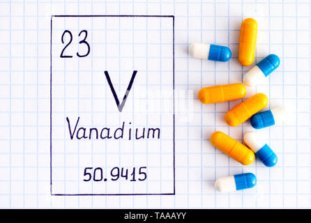 Handschrift chemische Element Vanadium V mit ein paar Pillen. Close-up. Stockfoto