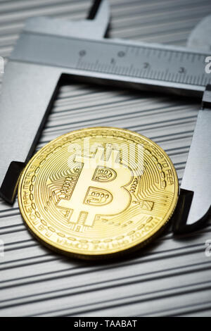 Bitcoin und Bremssattel auf einem Metalltisch. Stockfoto