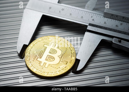 Bitcoin und Bremssattel auf einem Metalltisch. Stockfoto