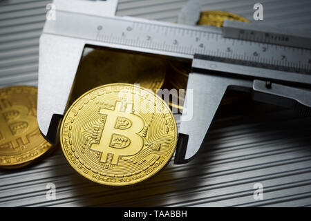 Bitcoins und Bremssattel auf einem Metalltisch. Stockfoto