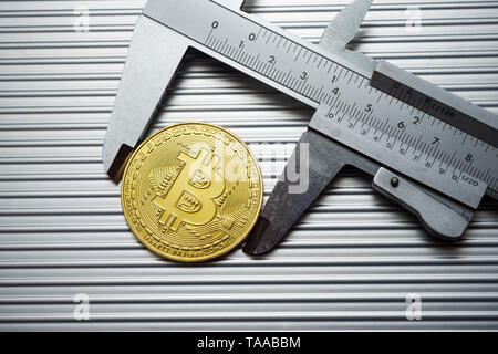 Bitcoin und Bremssattel auf einem Metalltisch. Stockfoto