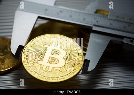 Bitcoins und Bremssattel auf einem Metalltisch. Stockfoto