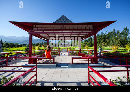 Frau in orange kleid und hut in der Pagode im Japanischen Garten. Stockfoto