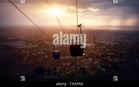 Silhouette der Seilbahn im City Blick auf dramatische stürmischen Sonnenuntergang Himmel Hintergrund Stockfoto