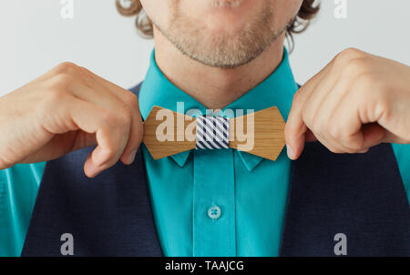 Junger Mann im blauen Hemd und Anzug korrigiert seine hölzernen bowtie Stockfoto
