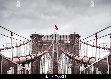 Riesige dramatischen Landschaft der Architektur der berühmten Brooklyn Bridge In New York City im Rahmen einer kontrastierenden stürmischen Himmel