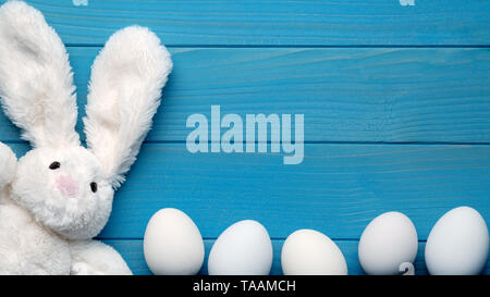 Osterhase mit Ostereiern auf Blau Holz- Hintergrund Stockfoto