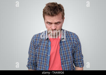 Zornigen jungen Mann an der Kamera schaut stirnrunzelnd Stockfoto